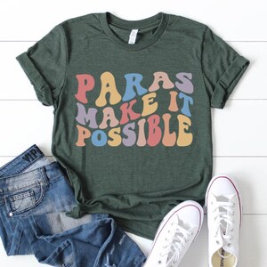 May include: A green t-shirt with the text "Paras Make It Possible" in rainbow colors. The text is in a retro, groovy font.