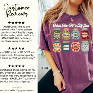 May include: Berry-colored t-shirt with the text "Pelvic Floor PT is My Jam" and illustrations of jam jars. Each jar has a label with a different pelvic floor health topic, such as "Kegels" and "Incontinence".