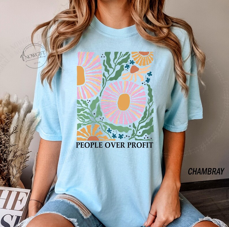 May include: A light blue t-shirt with a floral design and the text "People Over Profit".