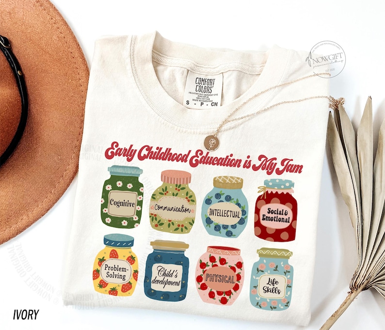Puede incluir: Una camiseta de color crema con el texto "Early Childhood Education is My Jam" en rojo. La camiseta presenta un gr&aacute;fico de nueve frascos con diferentes etiquetas, que incluyen "Cognitive", "Communication", "Intellectual", "Social & Emotional", "Problem-Solving", "Child's Development", "Physical" y "Life Skills".
