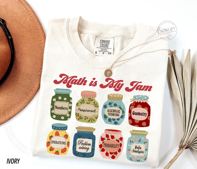 May include: A white t-shirt with the text "Math is My Jam" in red and a graphic of jars with different math concepts, such as numbers, measurement, algebraic thinking, geometry, operations, problem solving, probability, and data analysis.