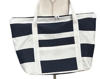 May include: A large tote bag with a navy blue and white striped pattern. The bag has white handles and a zipper closure. The bag is made of a sturdy material, perfect for carrying items.