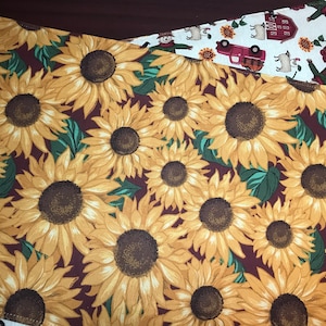 May include: A brown placemat with a pattern of yellow sunflowers on a burgundy background.