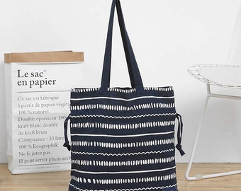 May include: A navy blue tote bag with white stripes and a white geometric pattern. The bag has a drawstring closure and a small label that says "Geometry Simple & Life".