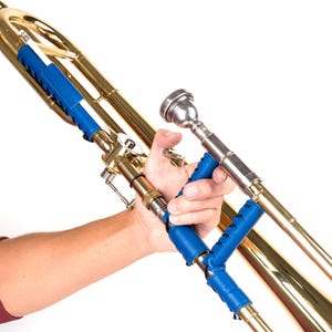 Op de afbeelding: Een gouden trombone met blauwe leren handvatten. De trombone wordt vastgehouden door een hand.