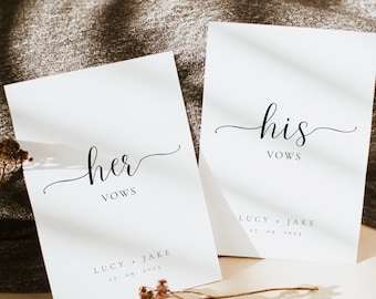 May include: Two white cards with black calligraphy that reads "her vows" and "his vows". The cards are on a brown textured surface with a dried flower sprig. The text below the vows reads "Lucy + Jake 27.09.2023".