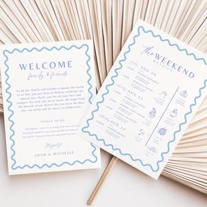 Könnte beinhalten: Zwei Hochzeitskarten mit blauen Wellenrändern. Auf einer Karte steht "WELCOME family & friends" und auf der anderen "The WEEKEND DETAILS" mit einem Zeitplan. Die Karten befinden sich auf einem hellbeigen Hintergrund.