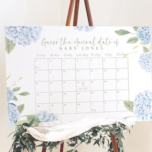 May include: A white calendar with blue hydrangea floral accents. The calendar is titled "Guess the Arrival Date of Baby Jones" and has a heart drawn on the 18th with the text "Our Date".