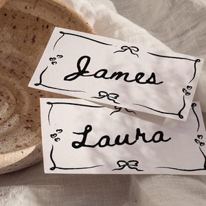 Tarjetas de lugar dibujadas a mano, tarjetas con nombres de boda originales escritas a mano, tarjetas de lugar con borde dibujado a mano, tarjetas de lugar para boda en francés