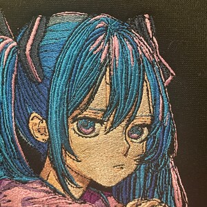 Puede incluir: Imagen bordada de un personaje de anime con cabello azul y ojos morados. El personaje lleva un atuendo rosa y morado y tiene una expresi&oacute;n triste.