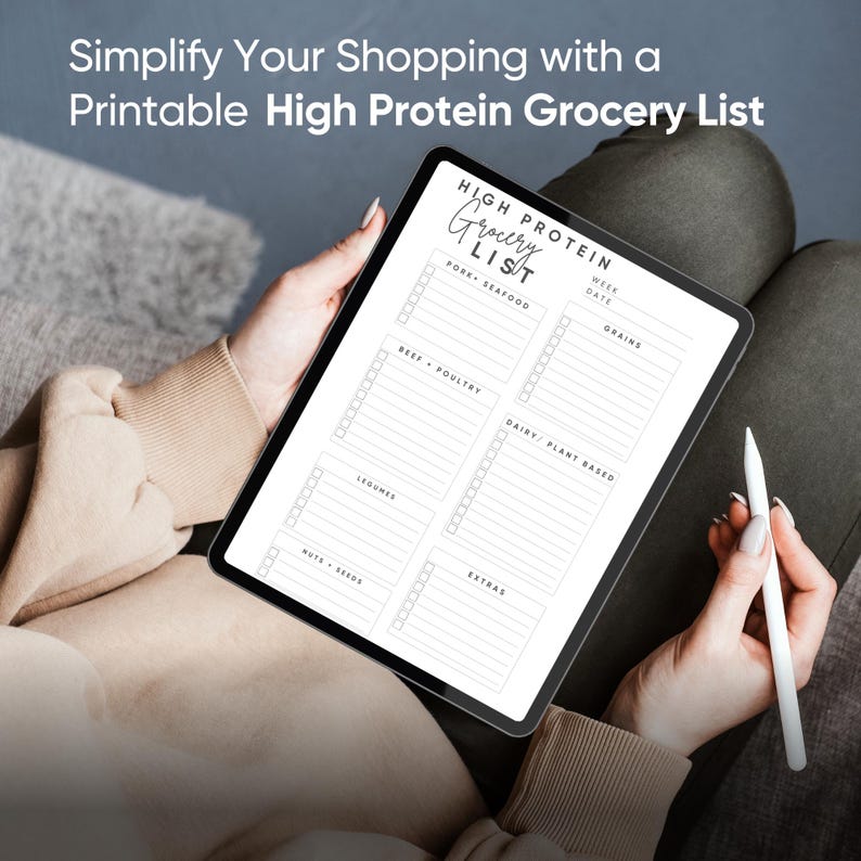 May include: A printable grocery list template on a tablet screen. The list is divided into categories: Pork & Seafood, Beef & Poultry, Legumes, Nuts & Seeds, Grains, Dairy & Plant Based, and Extras. Each category has checkboxes for items to be added.