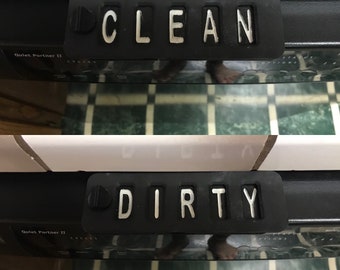 Puede incluir: Un panel de control de lavavajillas negro con un interruptor de palanca que dice "CLEAN" en un lado y "DIRTY" en el otro. El lavavajillas está etiquetado como "Quiet Partner II".