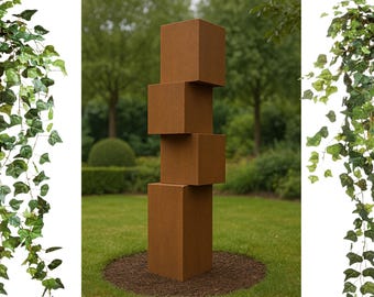 Könnte beinhalten: Eine Skulptur aus vier übereinander gestapelten, rostigen braunen Metallwürfeln in einer Gartenlandschaft. Die Skulptur ist von grünem Gras umgeben.