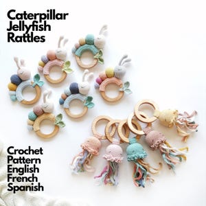 Peut inclure: Une collection de hochets faits main au crochet en forme de chenilles et de méduses avec des anneaux en bois. Les chenilles ont des corps segmentés aux couleurs pastel avec des antennes, tandis que les méduses ont des têtes rondes.