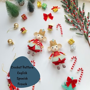 May include: A Christmas-themed display with two crocheted mouse figures in red and gold attire, alongside miniature decorations, candy canes, and gift boxes. The image includes text that reads "Crochet Pattern English Spanish French".