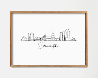 Könnte beinhalten: Eine Schwarzweiß-Zeichnung der Skyline von Edmonton, mit dem Städtenamen darunter. Die Zeichnung ist in einem hellen Holzrahmen gerahmt und hängt an einer weißen Wand.
