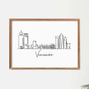 Puede incluir: Un dibujo en blanco y negro de la l&iacute;nea del horizonte de Vancouver enmarcado. El dibujo est&aacute; en un estilo de l&iacute;nea simple e incluye el texto "Vancouver" debajo del horizonte.