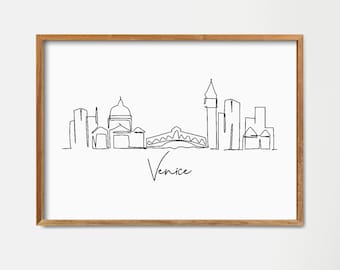 Könnte beinhalten: Eine Schwarzweiß-Zeichnung der Skyline von Venedig, einschließlich der Rialtobrücke und des Dogenpalastes. Die Zeichnung ist in einem hellen Holzrahmen gerahmt und hängt an einer weißen Wand.