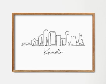 May include: A framed black and white line drawing of the Knoxville skyline. The drawing is in a simple line style and includes the text "Knoxville" below the skyline.