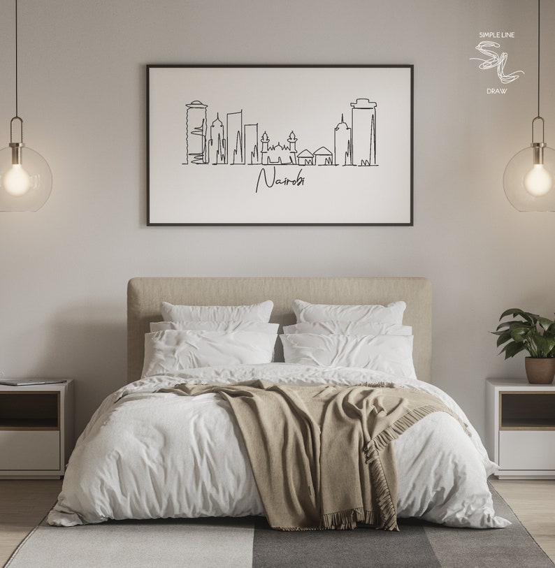 Puede incluir: Un dibujo lineal en blanco y negro enmarcado del horizonte de Nairobi cuelga sobre una cama con ropa de cama blanca y una manta beige. El texto "Nairobi" est&aacute; escrito debajo del horizonte. La habitaci&oacute;n est&aacute; decorada con l&aacute;mparas modernas y mesitas de noche.