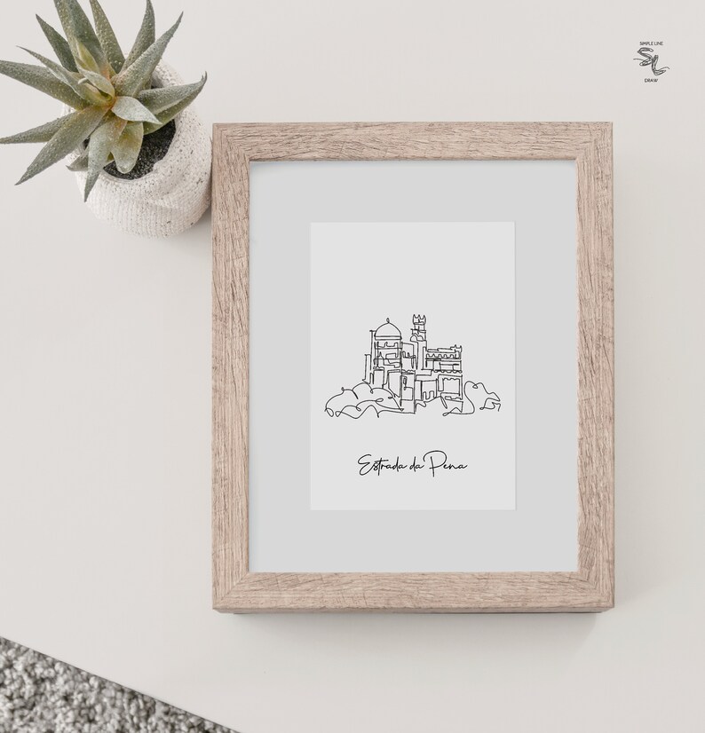 May include: A black and white line drawing of the Pena Palace in Sintra, Portugal. The drawing is framed in a light brown wood frame. The text "Estoril do Pena" is written below the drawing.