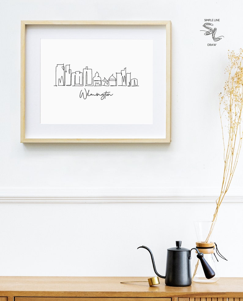 May include: A framed black and white line drawing of the Wilmington skyline with the text "Wilmington" below the drawing.