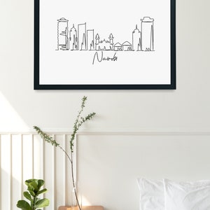 Puede incluir: Impresi&oacute;n art&iacute;stica enmarcada en negro con un dibujo lineal minimalista del horizonte de Nairobi. La obra de arte es en blanco y negro, con el nombre de la ciudad escrito en cursiva debajo del horizonte. El texto "Simple Line Draw" est&aacute; en la esquina inferior derecha.