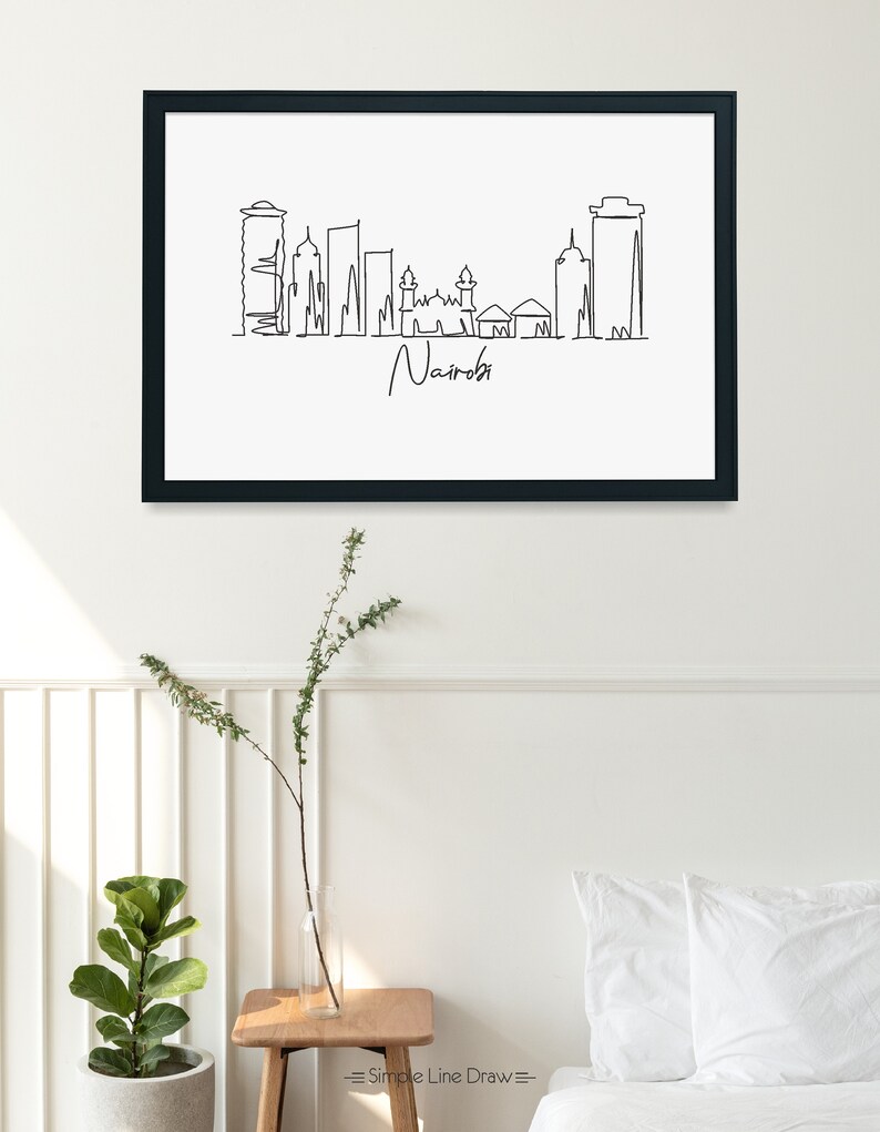 Puede incluir: Impresi&oacute;n art&iacute;stica enmarcada en negro con un dibujo lineal minimalista del horizonte de Nairobi. La obra de arte es en blanco y negro, con el nombre de la ciudad escrito en cursiva debajo del horizonte. El texto "Simple Line Draw" est&aacute; en la esquina inferior derecha.