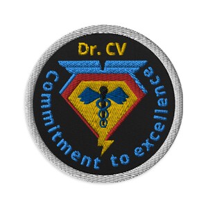 May include: A black and white embroidered patch with a diamond shape in the center. The diamond is yellow with a blue medical symbol and a lightning bolt at the bottom. The text "Dr. CV Commitment to excellence" is written in a circle around the diamond.