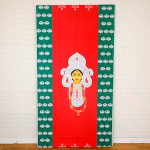 May include: A red fabric backdrop with green borders featuring a white and gold illustration of a goddess with a crown and ornate jewellery. The backdrop is decorated with a repeating pattern of white lotus flowers on a green background.