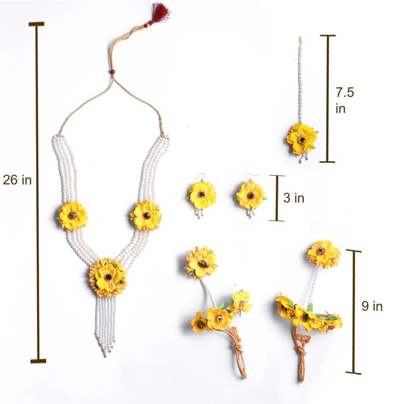 May include: A yellow flower jewelry set with a pearl necklace, earrings, a maang tikka, and two bangles. The necklace is 26 inches long, the earrings are 3 inches long, the maang tikka is 7.5 inches long, and the bangles are 9 inches long.