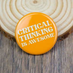 May include: A bright orange button with the text "CRITICAL THINKING IS AWESOME" in white letters.