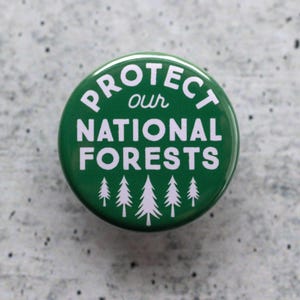 May include: Green button with white text that reads "Protect our National Forests" with a row of five white stylized pine trees at the bottom.