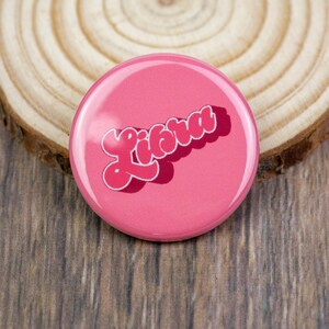 May include: A pink button with the word "Licra" written in a retro font style.
