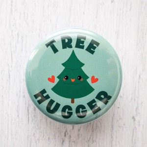 May include: A green and blue button with the text "TREE HUGGER" in black letters. A cartoon green tree with a smiling face and red hearts is in the center of the button.