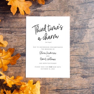 May include: A white wedding announcement card with the text "Third time's a charm (we hope)". The announcement states that the wedding of Olivia Henderson and Robert Williams has been postponed to October 14, 2021.