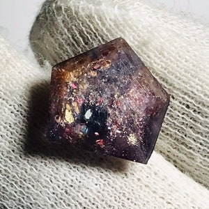 May include: A purple, iridescent, geometric resin piece with gold and silver glitter embedded inside. The piece is shaped like a diamond and has a smooth, polished finish.