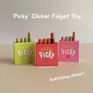 Puede incluir: Tres juguetes fidget clicker 'Picky' de colores. Cada juguete tiene una caja rectangular con la palabra 'Picky' y un gráfico. Las cajas son de color verde lima, rojo y rosa. Los juguetes tienen piezas cilíndricas de madera y de colores que hacen clic.