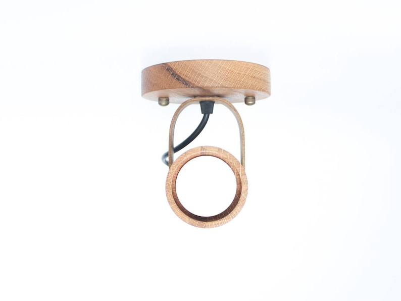 May include: A wooden ceiling light fixture with a circular shade and a black wire.