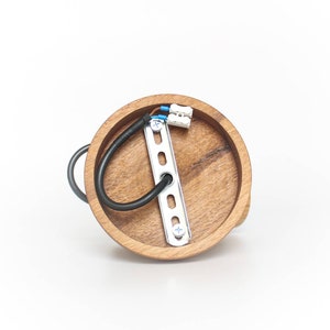 May include: A round wooden ceiling light fixture with a metal mounting plate and wiring. The fixture is made of natural wood with a light brown finish.