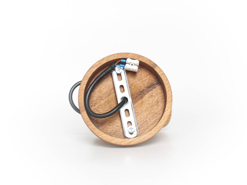 May include: A round wooden ceiling light fixture with a metal mounting plate and wiring. The fixture is made of natural wood with a light brown finish.