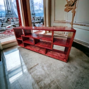 May include: A red wooden shelf unit with multiple open shelves. The shelf unit is made of reclaimed wood and has a rustic look.