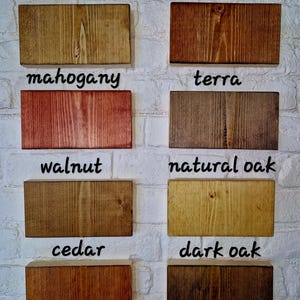 May include: Eight wood samples stained in different colors, labeled with their names: medium oak, rosewood, mahogany, terra, walnut, natural oak, cedar, and dark oak.