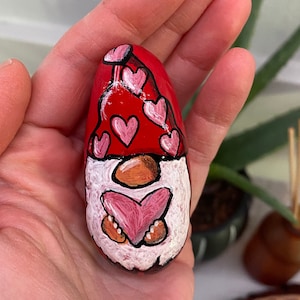 Valentine’s Day themed hand painted rock. Hand painted garden gnome holding a heart.