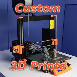 May include: A black and orange 3D printer with a spool of white filament. The printer is printing a small gray Yoda figurine and a tower. The printer is on a white surface. The text "Custom 3D Prints" is in large red letters above the printer.