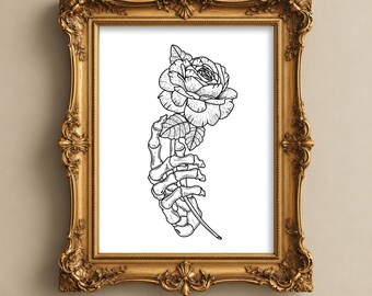 May include: A black and white line art illustration of a skeletal hand holding a single rose, displayed within an ornate, rectangular gold-colored frame with intricate carved detailing along the edges and corners.