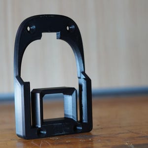Black 3D printed RIDGID 18V battery mount standing upright on workbench