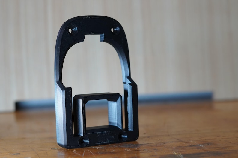 Black 3D printed RIDGID 18V battery mount standing upright on workbench