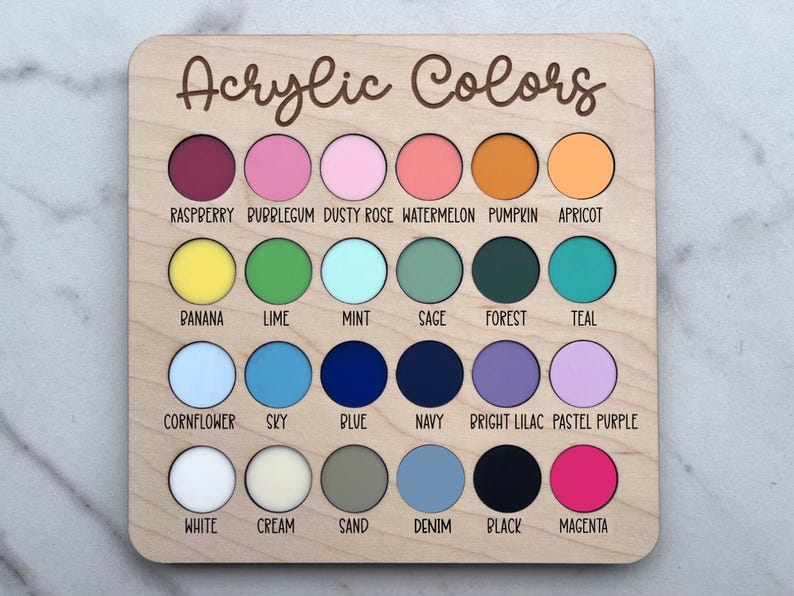 K&ouml;nnte beinhalten: Ein quadratisches Holzbrett mit der Aufschrift Acrylic Colors und vierundzwanzig kreisf&ouml;rmigen Ausstanzungen, die mit verschiedenen Acrylfarbmustern gef&uuml;llt sind. Jeder Kreis ist mit dem entsprechenden Farbnamen beschriftet, darunter raspberry, bubblegum, dusty rose, watermelon, pumpkin, apricot, banana, lime, mint, sage, forest, teal, cornflower, sky, blue, navy, bright lilac, pastel purple, white, cream, sand, denim, black und magenta.