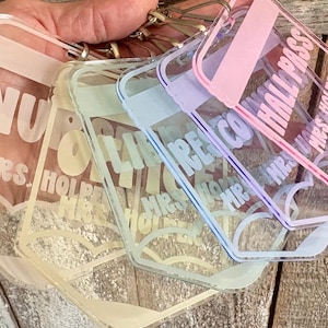 May include: A set of four rectangular clear acrylic keychains with rounded corners, each featuring a pastel-colored border and printed text. The text on the keychains includes the words HALL PASS and MRS. HOLPER, along with heart-shaped graphics.